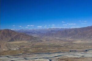 Expansive Tibetan valley under a blue sky