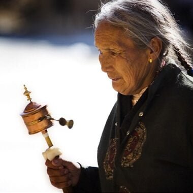 An Old Pilgrim Lady in Tibet - with a Hand Prayer Wheel