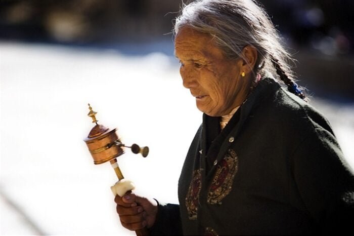 An Old Pilgrim Lady in Tibet - with a Hand Prayer Wheel