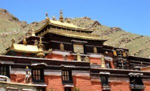 The sprawling Tashilumpo Monastery complex, with golden rooftops and vibrant prayer flags.