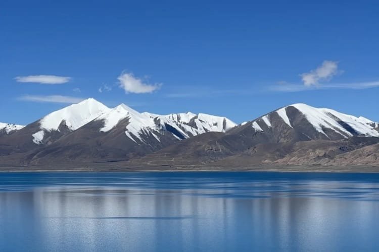 Lake Pelkutso and snow-capped mountain reflections during 7-day Lhasa-Kathmandu group tour Tibet