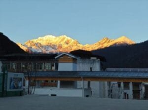 View of Lulang Town with golden snow-capped mountains in the distance during Tibet’s Peach Blossom Festival.