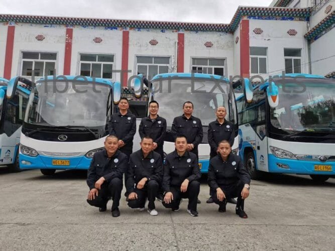 Tibet Tour Experts drivers posing in the company parking lot with tour buses in the background