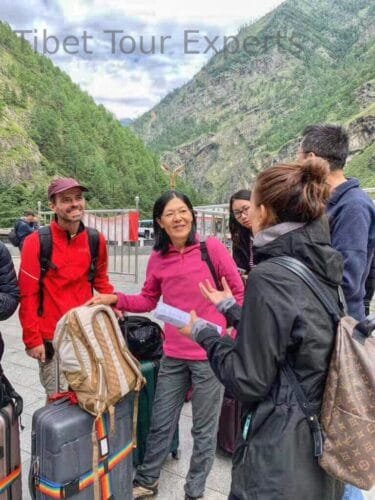 Tibet Tour Experts guide welcoming travelers at the Tibet-Nepal border