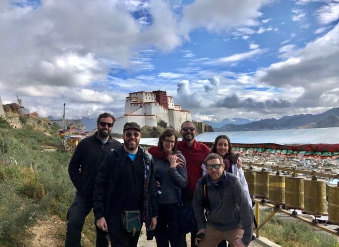 Travelers posing in a quiet area behind the Potala Palace in Lhasa, Tibet.
