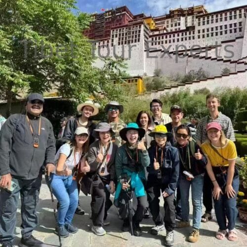 International tour group travelling with Tibet Tour Experts and posing happily in front of the Potala Palace