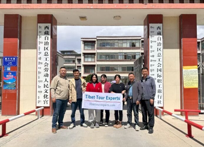 Staff of Tibet Tour Experts standing at the company entrance in Lhasa